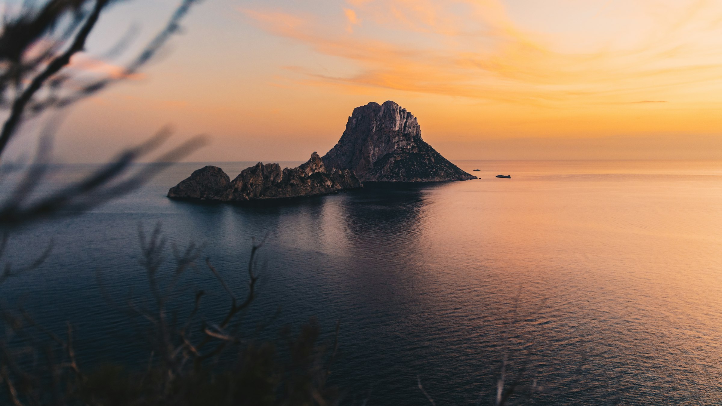 Atardecer dorado sobre un islote rocoso en el mar Mediterráneo
