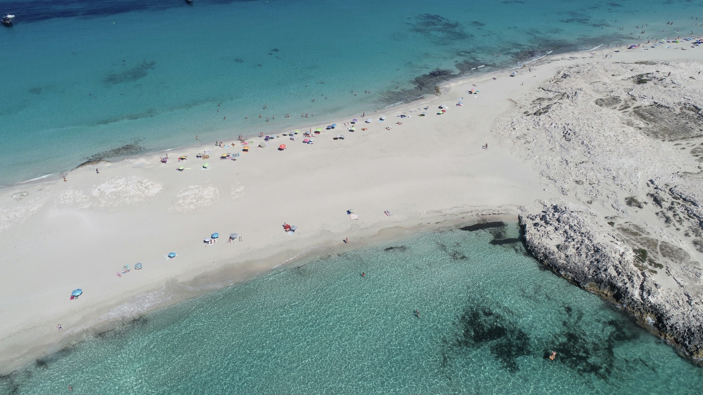 Vista aérea de una cala mediterránea de aguas turquesas y arena blanca
